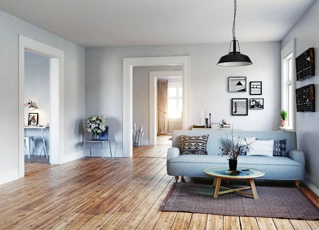 A living room with hard wood floors and white walls.