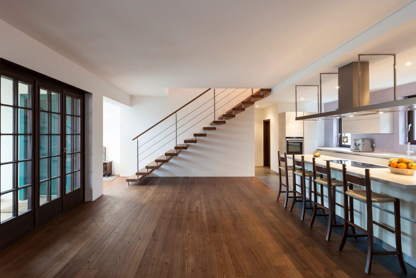 A room with wooden floors and stairs leading to the top floor.